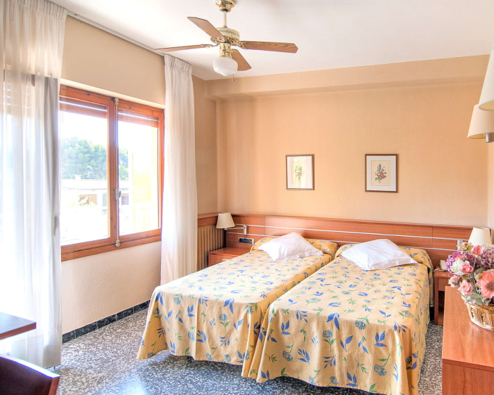 Single Room_Yellow Beds Two beds together with yellow bedspreads with blue flowers