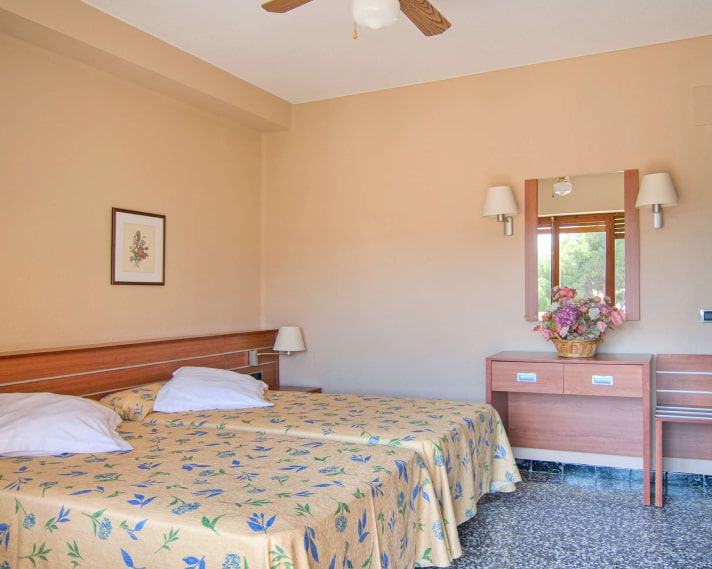 Triple Room_Yellow Beds Room with two beds next to each other, with yellow bedspreads with blue flowers