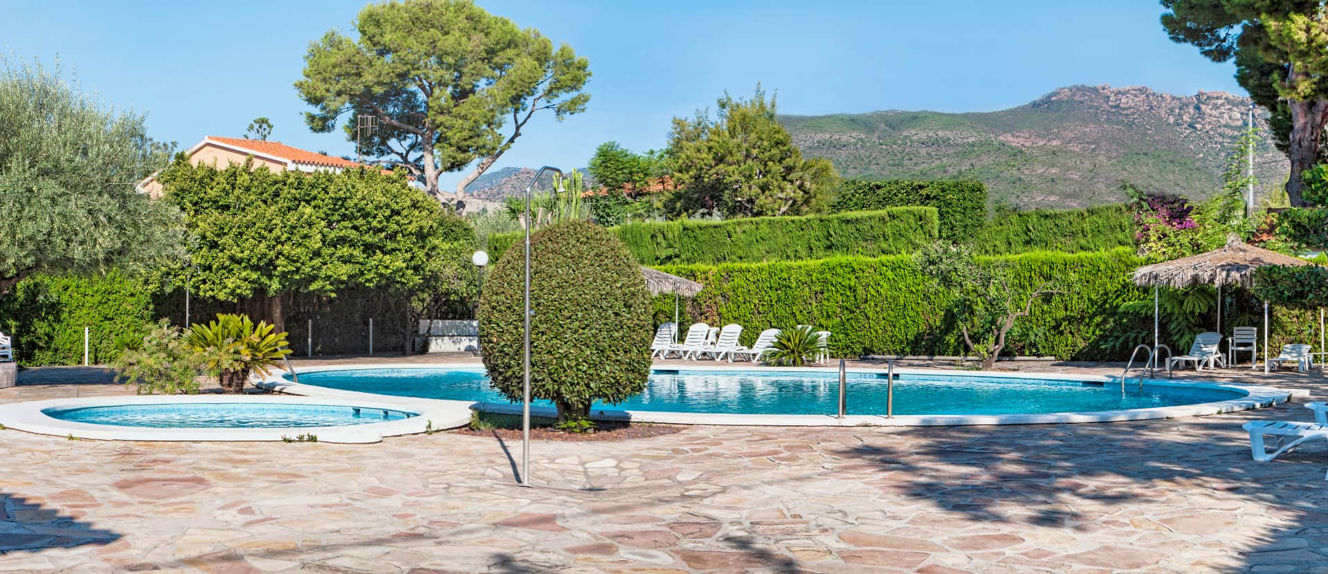 Outdoor Pool General view of the pool area, with a large pool and a children's pool.